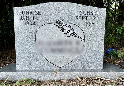 Upright granite headstone with heart engraving — after cleaning