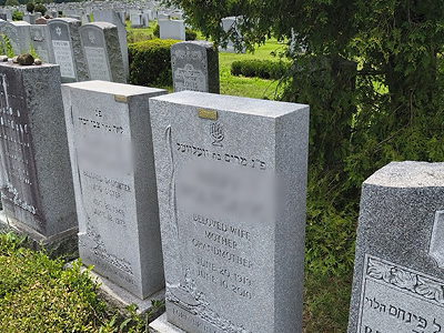Upright granite headstone in a cemetery row — after cleaning